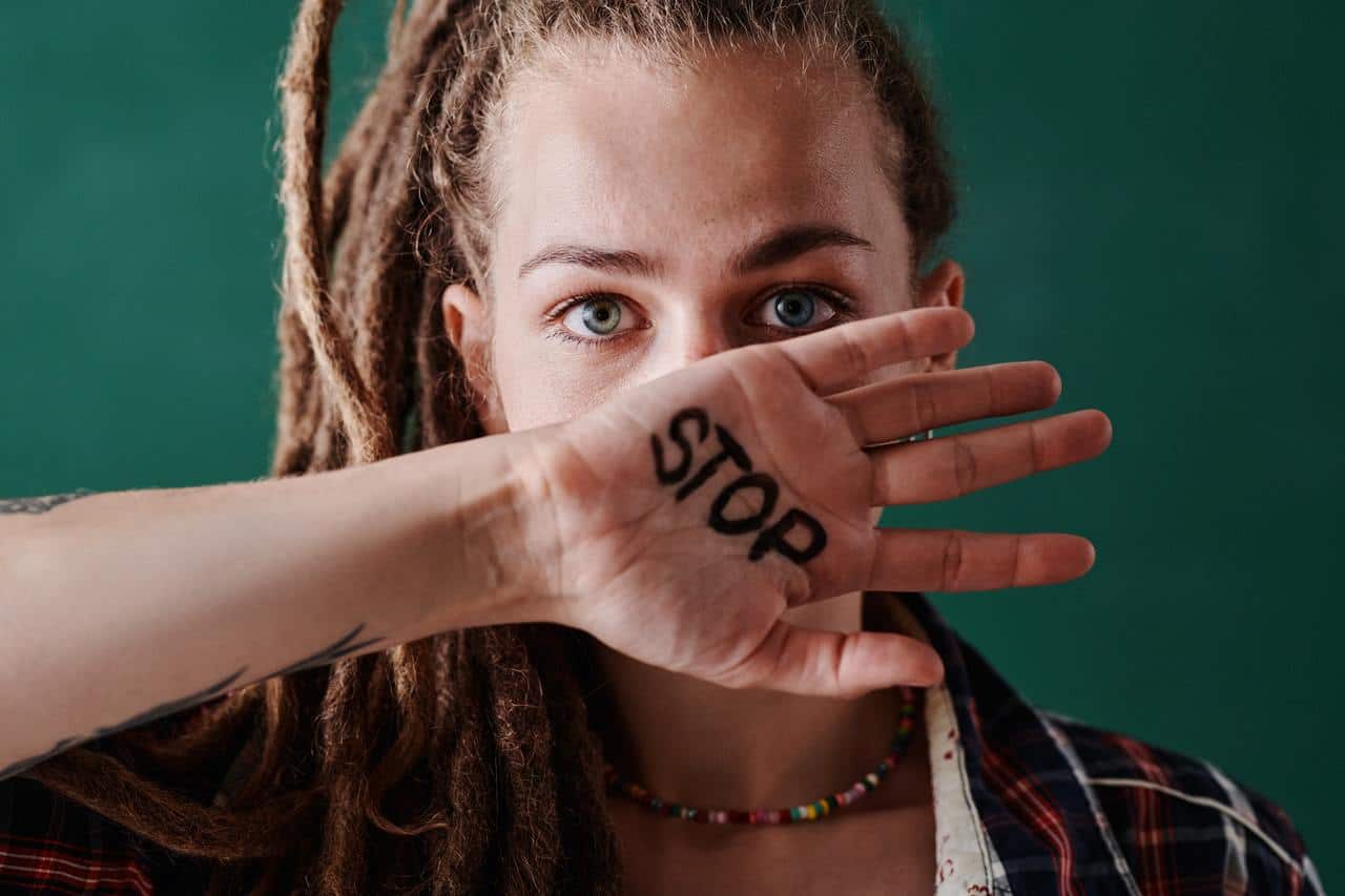 בחורה אשר עברה הטרדה מינית עם כיתוב על היד של "עצור"
